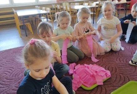 dzieci tworzą kwiaty  z krepy