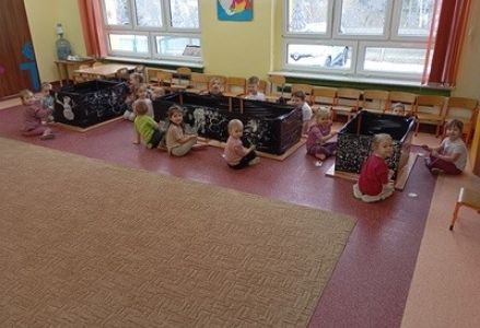grupa dzieci przedszkolnych podczas zajęć plastycznych z wykorzystaniem techniki malowania na folii sterczowej