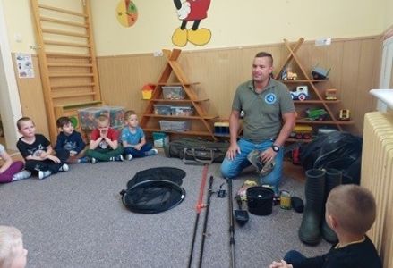 grupa dzieci przedszkolnych podczas spotkania z wędkarzem