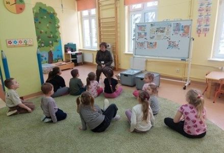 grupa dzieci przedszkolnych podczas zajęć przyrodniczych o dokarmianiu ptaków zimą