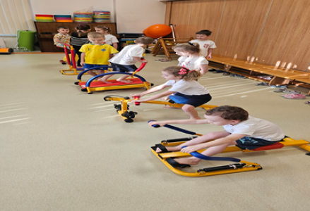 Dzieci z grupy przedszkolnej podczas zajęć gimnastycznych na mini siłowni.