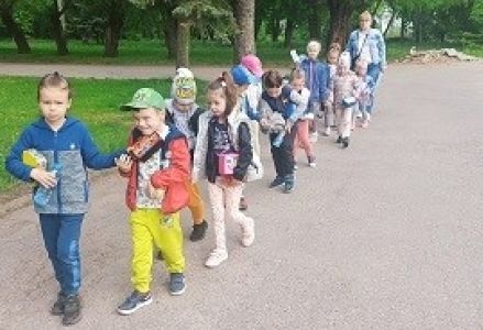 dzieci idą parami przez parking