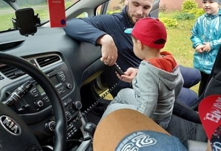 policjant opisuje dzieciom wyposażenie samochodu