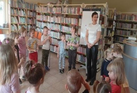 grupa dzieci przedszkolnych podczas wiosennej wizyty w bibliotece