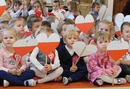dzieci trzymają serduszka patriotyczne