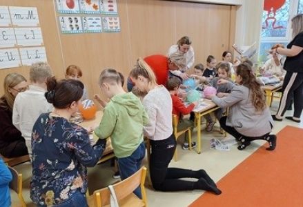 grupa dzieci przedszkolnych podczas jesiennych zajęć otwartych z rodzicami