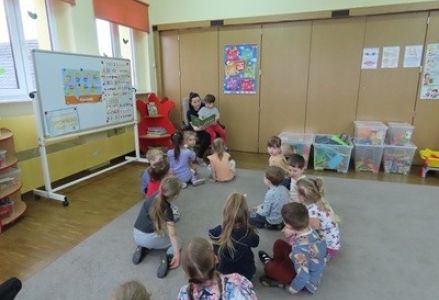 Dzieci z grupy przedszkolnej podczas czytania bajki przez mamę Leona.