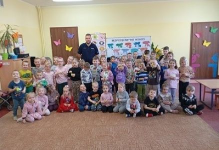 grupa dzieci przedszkolnych podczas spotkania z policjantem na temat bezpieczeństwa w sieci