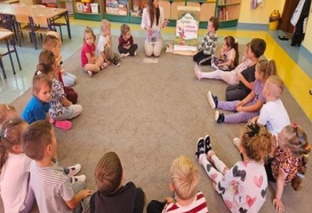 grupa dzieci przedszkolnych podczas wizyty bibliotekarki w ramach akcji "Mała książka - Wielki człowiek"