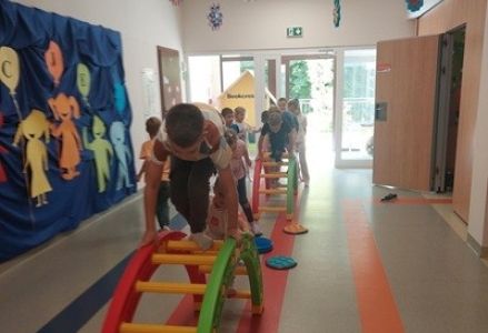 grupa dzieci przedszkolnych podczas zabaw ruchowych i korzystania ze ścieżki sensorycznej